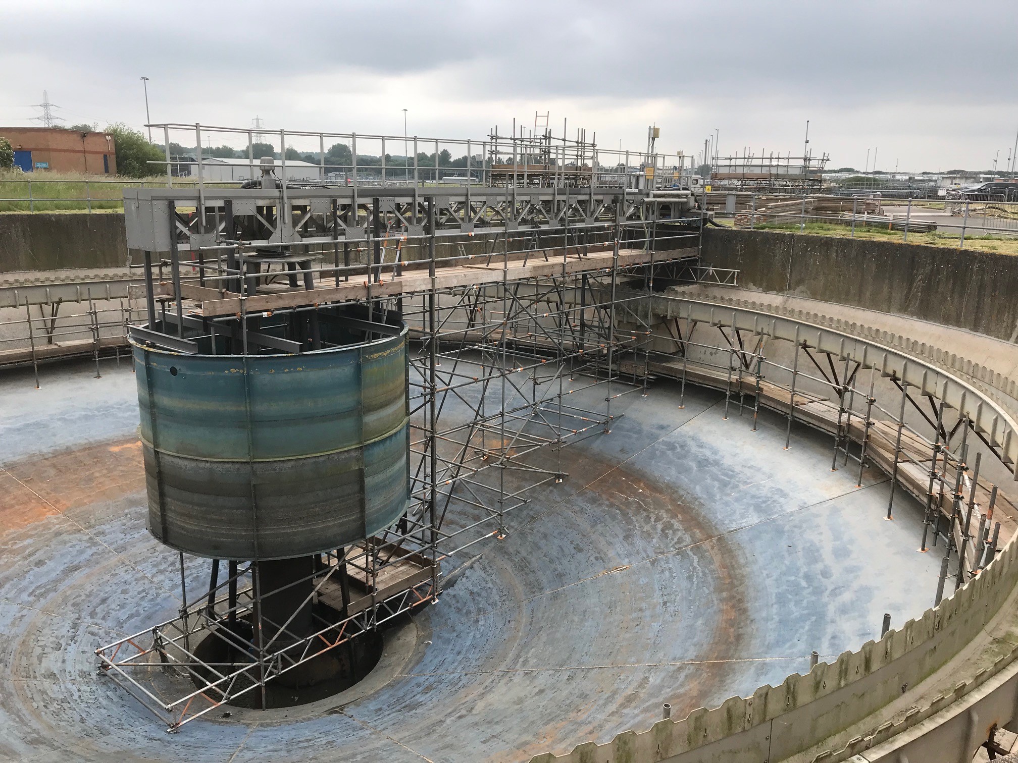 An image of scaffolding creating a bridge between a sewage tank and higher ground