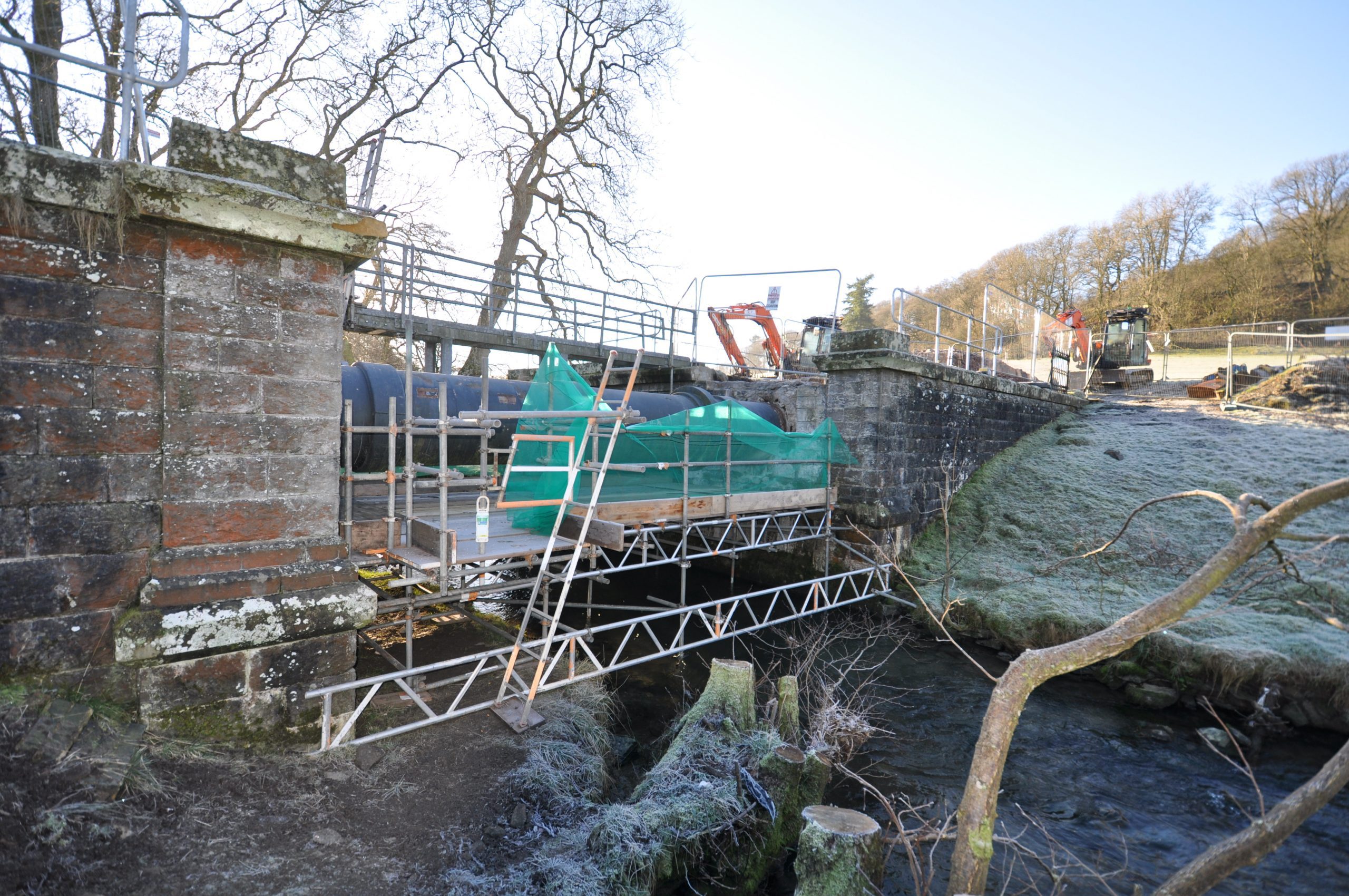 An image of scaffolding suspended over a river bed
